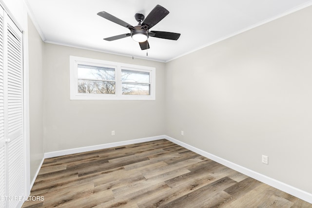 unfurnished bedroom with hardwood / wood-style flooring, crown molding, ceiling fan, and a closet