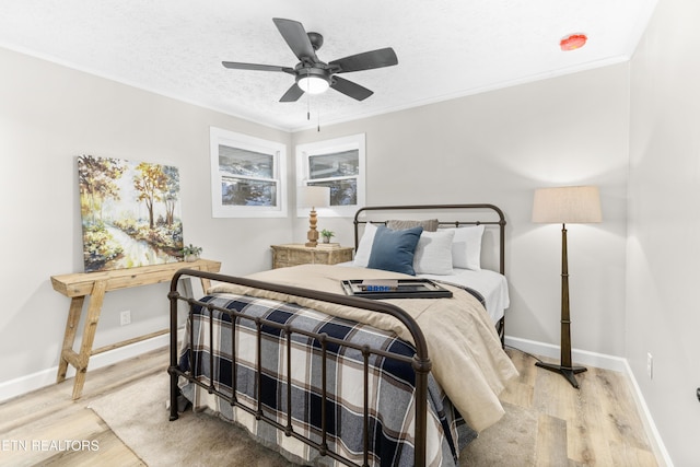 bedroom featuring hardwood / wood-style floors, ornamental molding, a textured ceiling, and ceiling fan