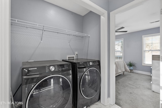 clothes washing area with light carpet, separate washer and dryer, and ceiling fan