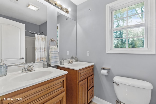 bathroom featuring toilet, vanity, and a shower with shower curtain