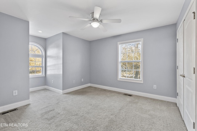 carpeted spare room with ceiling fan