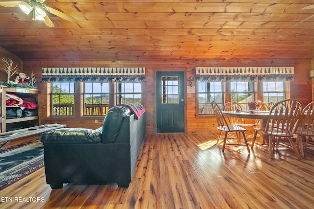 living room with hardwood / wood-style floors, wooden walls, a wealth of natural light, and wooden ceiling