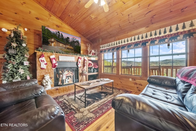 living room with wooden ceiling, ceiling fan, wooden walls, hardwood / wood-style flooring, and lofted ceiling