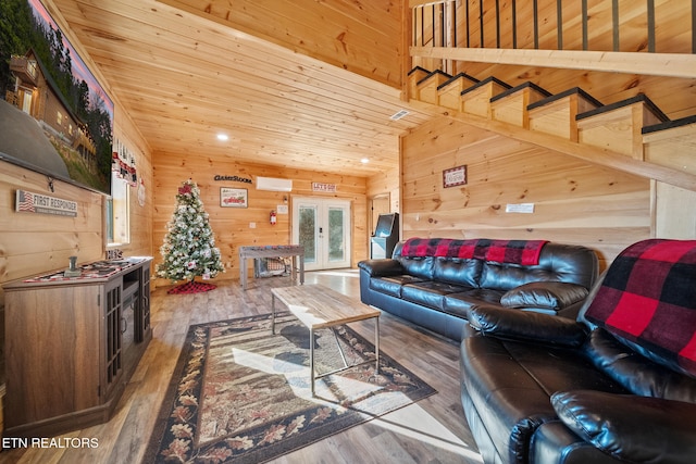 living room featuring french doors, wooden ceiling, wood walls, and hardwood / wood-style floors