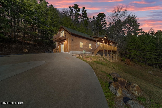 view of front of property with a deck, a lawn, and a garage