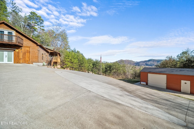 view of property exterior featuring a garage, a mountain view, and an outdoor structure