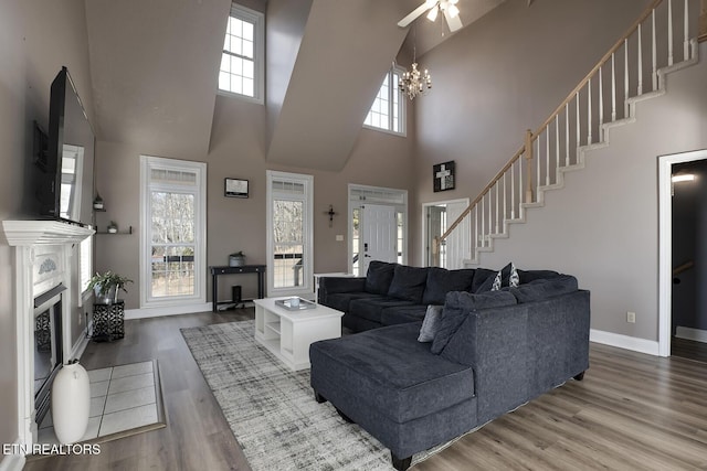 living room featuring wood-type flooring, a chandelier, and a high ceiling