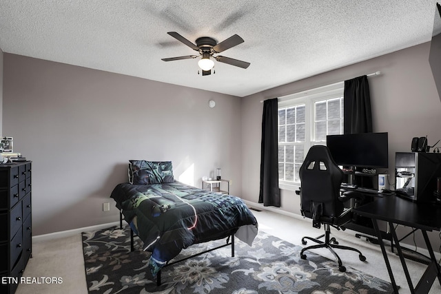 carpeted bedroom featuring ceiling fan and a textured ceiling