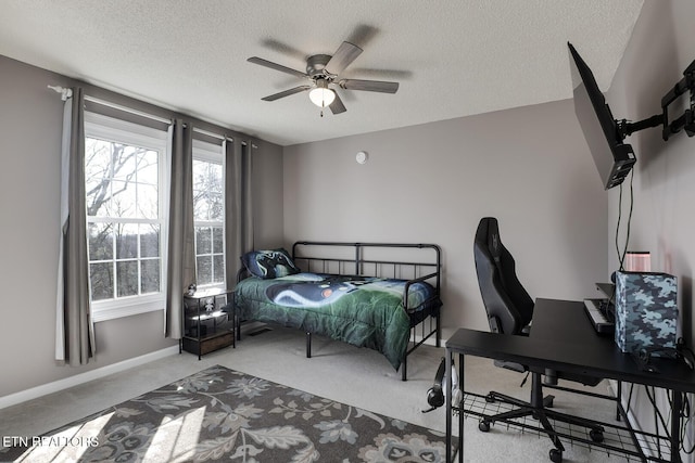 bedroom with ceiling fan, carpet flooring, and a textured ceiling