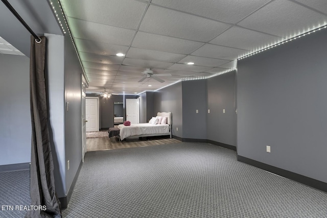 unfurnished bedroom with carpet floors, a paneled ceiling, and ceiling fan