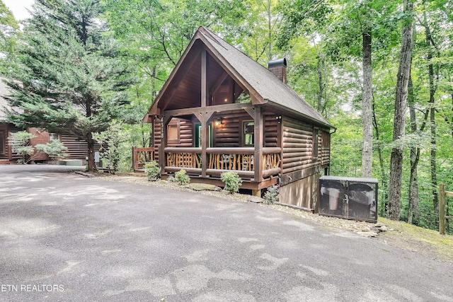 log-style house featuring covered porch