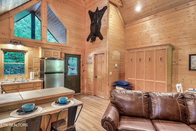 living room featuring high vaulted ceiling and wooden walls