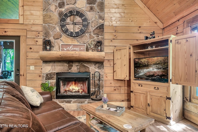 living room with a fireplace, wood walls, wood ceiling, and vaulted ceiling