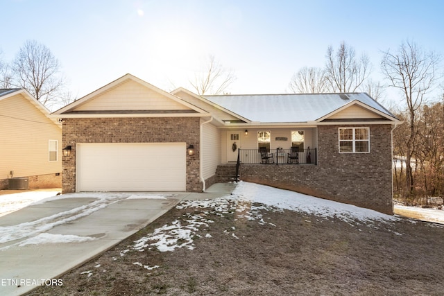 single story home featuring cooling unit, covered porch, and a garage