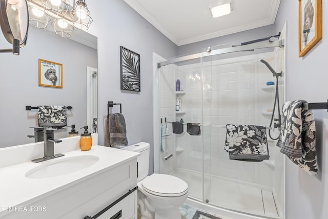 bathroom featuring toilet, vanity, ornamental molding, and a shower with shower door