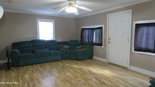 living room featuring ceiling fan, ornamental molding, and wood-type flooring