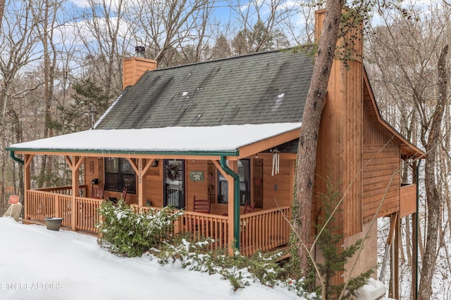 snow covered property with a porch