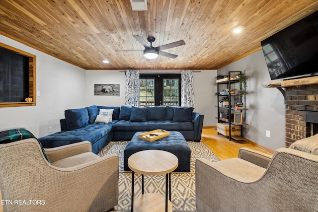 living room with a brick fireplace, ceiling fan, light hardwood / wood-style floors, and wooden ceiling