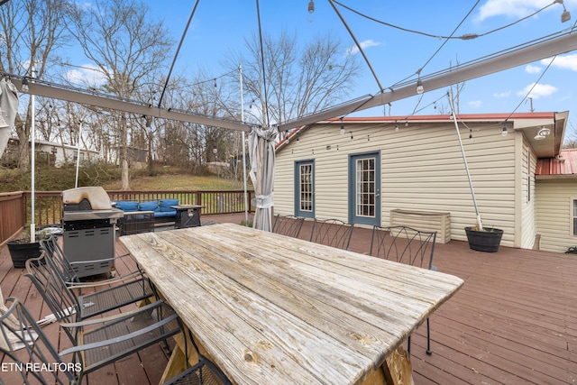 wooden deck featuring an outdoor living space and a grill