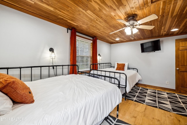 bedroom featuring ornamental molding, wood-type flooring, ceiling fan, and wooden ceiling