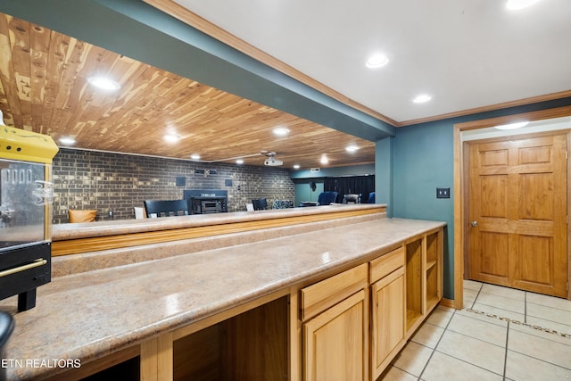 kitchen featuring light tile patterned floors, tasteful backsplash, a wood stove, ornamental molding, and wooden ceiling