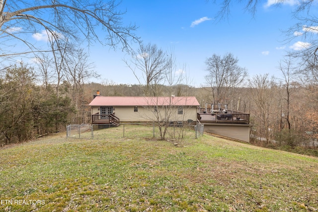 back of property with a yard and a wooden deck