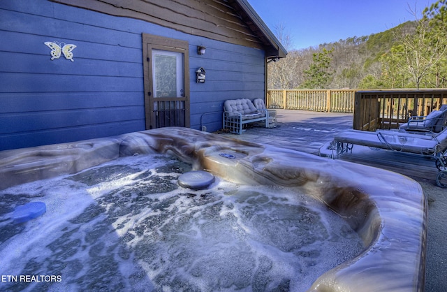 wooden deck with a hot tub and a mountain view