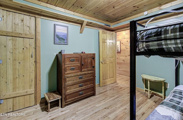 bedroom featuring wooden walls, light hardwood / wood-style floors, and wood ceiling