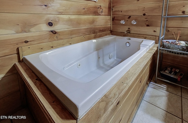 bathroom with wooden walls, a bath, and tile patterned floors