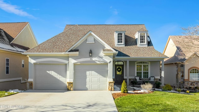 view of front of home featuring a porch, a front yard, and a garage