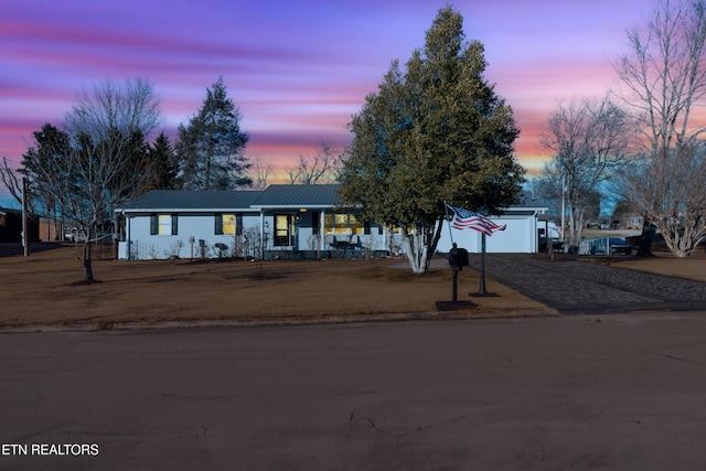 single story home featuring a porch and a garage