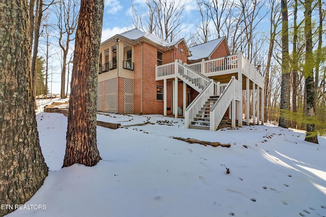 snow covered property with a balcony