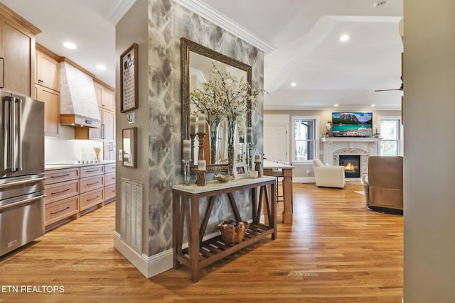 hallway featuring ornamental molding and light hardwood / wood-style flooring