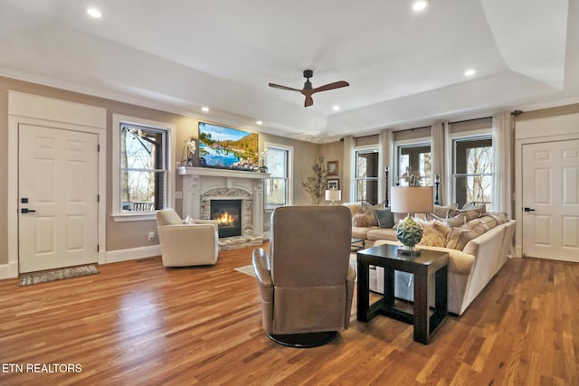 living room featuring a raised ceiling, hardwood / wood-style flooring, and ceiling fan