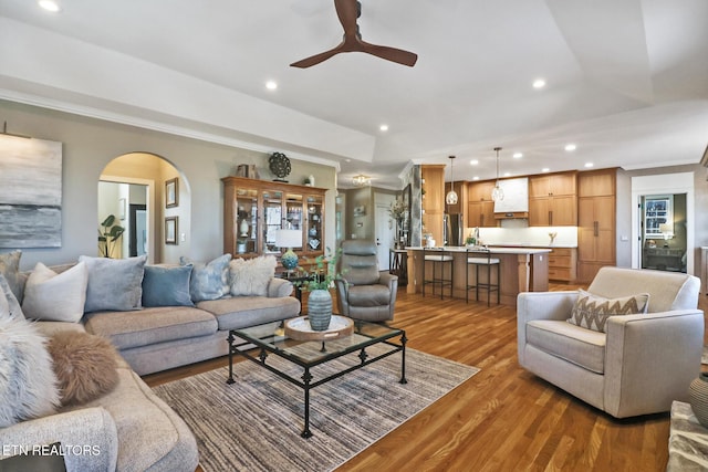 living room with crown molding, ceiling fan, and dark hardwood / wood-style flooring