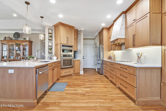 kitchen featuring stainless steel appliances, decorative light fixtures, light brown cabinetry, and sink