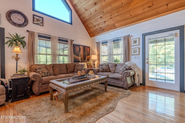 living room featuring high vaulted ceiling, light hardwood / wood-style flooring, wood ceiling, and wooden walls