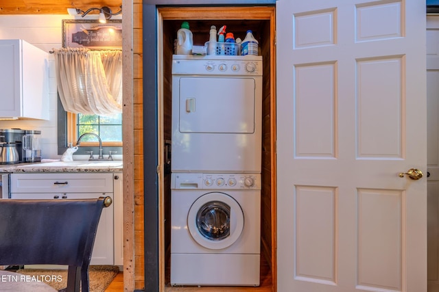 washroom with sink and stacked washer / dryer