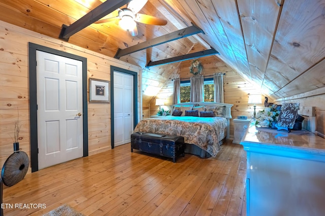 bedroom featuring wood ceiling, light hardwood / wood-style floors, wood walls, ceiling fan, and vaulted ceiling with beams