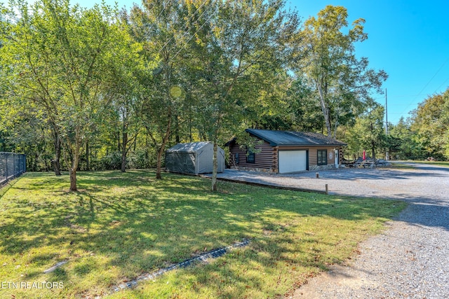 view of yard with a garage and an outbuilding