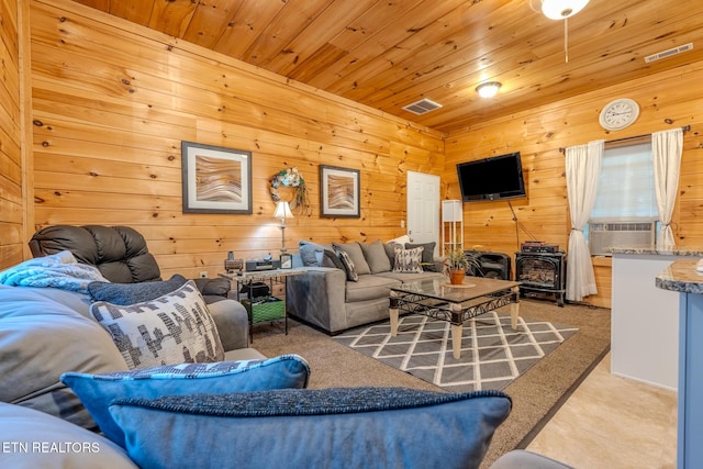 carpeted living room featuring wooden ceiling, a wood stove, and wooden walls