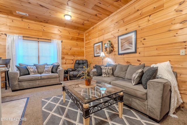 carpeted living room with wood ceiling and wooden walls