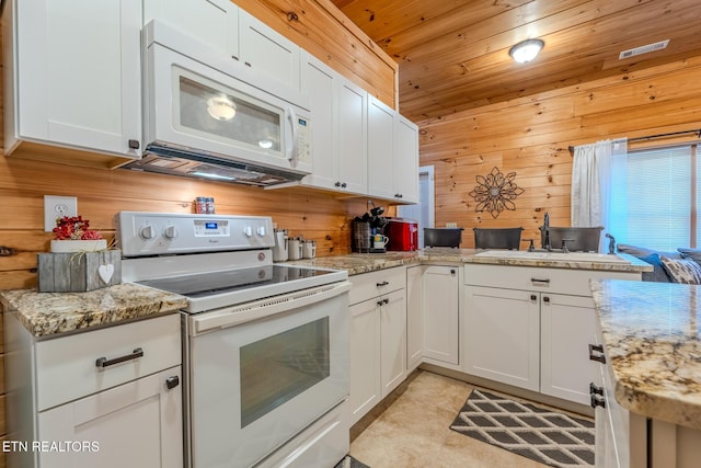 kitchen featuring white appliances, white cabinetry, kitchen peninsula, wood walls, and wooden ceiling