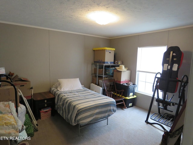 carpeted bedroom with a textured ceiling and crown molding