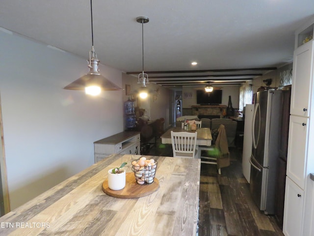 dining room featuring a fireplace and dark wood-style flooring