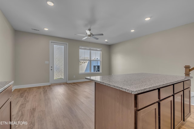 kitchen with a kitchen island, ceiling fan, and light hardwood / wood-style floors