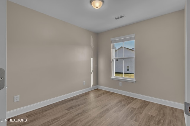 empty room with light hardwood / wood-style floors and a wealth of natural light