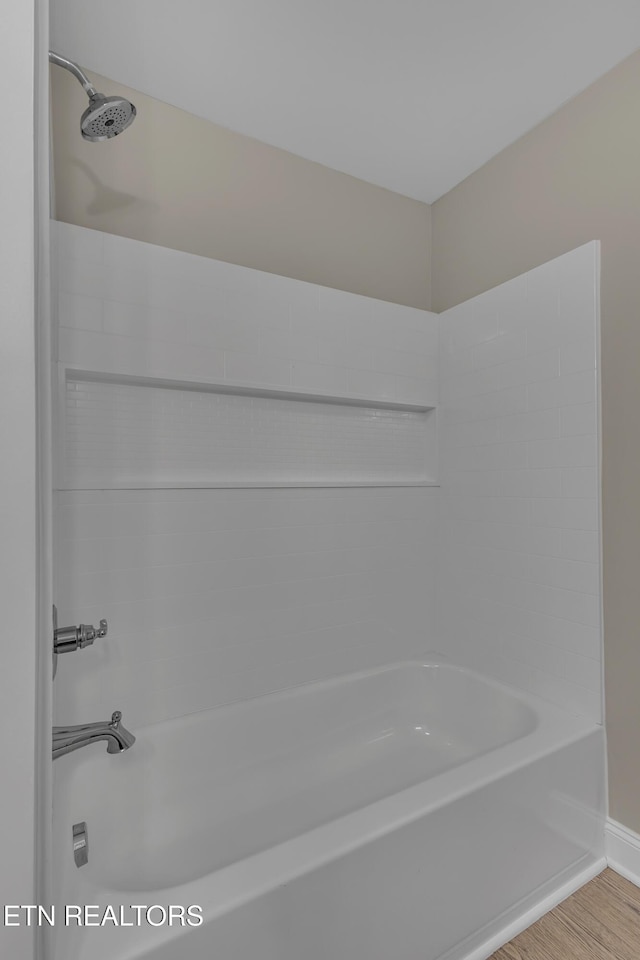 bathroom featuring bathtub / shower combination and hardwood / wood-style flooring