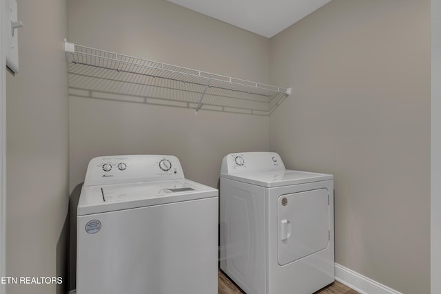 clothes washing area with independent washer and dryer and hardwood / wood-style floors