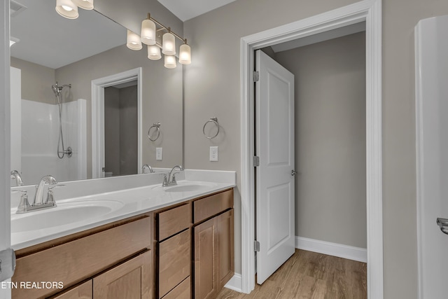 bathroom featuring wood-type flooring, vanity, and walk in shower